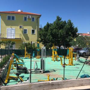 比利切Lipovac resort Ficus的大楼前的游乐场,配有黄色设备