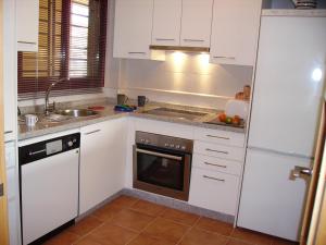 卡拉德米哈斯Málaga, Mijas, La Cala, apartamento vacaciones de ensueño的厨房配有白色橱柜、水槽和洗碗机。