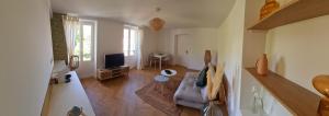 瓦兹河畔欧韦L'App'Art d'Auvers的带沙发和电视的客厅
