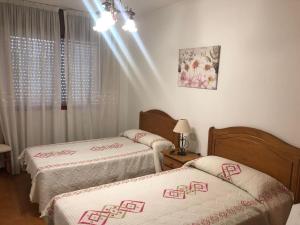 拉科萨Piso centro de Raxò的客房设有两张床和窗户。