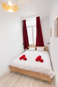 那慕尔Les Cerisiers - Appart de Standing à Namur Centre的一间卧室配有一张带红色枕头的床