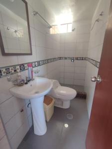 CoporaqueWayra Wasi的白色的浴室设有水槽和卫生间。