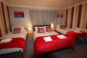 萨顿因阿什菲尔德Aspley House的酒店客房,配有三张带红色床单的床