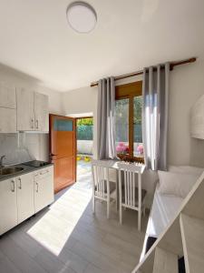 伏罗拉Sunny guest house的厨房以及带桌椅的起居室。