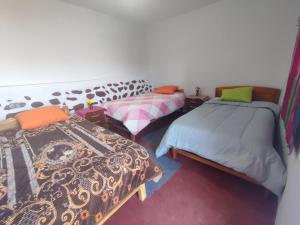CoporaqueWayra Wasi的一间客房内配有两张床的房间