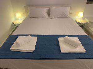 提诺斯BIANCO BLUE的床上有两条毛巾