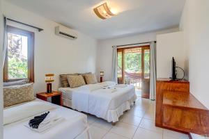 伊塔卡雷巴尔卡萨博萨达酒店的一间卧室配有两张床和电视。
