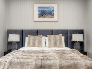 金德拜恩Chalet Alpina的一间卧室配有一张大床和两盏灯