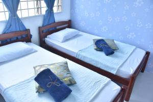 马日丹那BenBahrains Homestay - PB - ISLAMIC COMPLIANCE ONLY的蓝色墙壁客房中的两张单人床