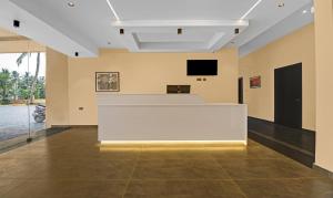 科钦Treebo Trend Grand Vistara Airport Suites的大房间设有白色的柜台和平面电视