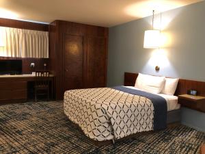 新奥尔良市Curly Redwood Lodge的配有一张床和一张书桌的酒店客房
