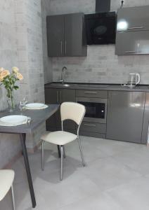 尼古拉耶夫1 кк люкс лофт студия的厨房配有桌椅和水槽。
