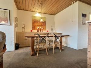 丁诺高原Snow Gums Apartment 4, alpine-getaways的一间带木桌和椅子的用餐室