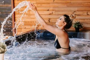 普雷代亚尔Elexus Boutique的穿着泳衣的女人在浴缸里玩水