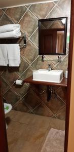 马普托1109宾馆的浴室设有水槽和墙上的镜子
