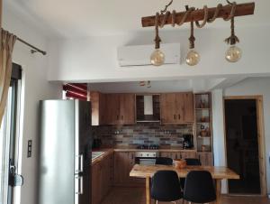 依克希亚Olivelia的厨房配有木制橱柜和木桌。
