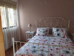 依克希亚Olivelia的卧室配有白色床和花卉床罩