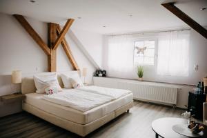 韦因斯特拉塞地区瓦亨海姆奥斯塔德曼茨旅馆的卧室设有一张白色大床和一扇窗户。
