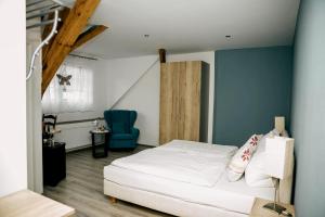 韦因斯特拉塞地区瓦亨海姆奥斯塔德曼茨旅馆的卧室配有白色的床和蓝色的墙壁