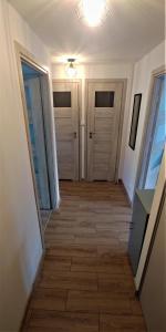苏瓦乌基M&M Suwałki Centrum的走廊设有两扇门,铺有瓷砖地板