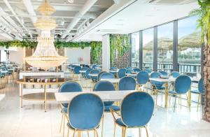 济州市济州优拓由布莱斯酒店的一间设有蓝色椅子和桌子的用餐室以及窗户。