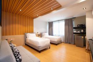 Ban Yangโรงแรมอินฟินิทเกษตร的酒店客房,设有两张床和一张沙发