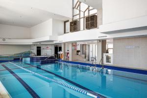 荷兹利亚Water Front Luxury Family Apartment的大楼内一个蓝色的大型游泳池