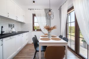 卡尔维亚ZIELONE MIEJSCE - klimatyczny domek nad morzem的白色的厨房配有白色的桌子和椅子