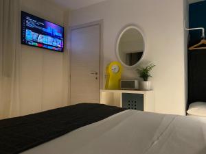 圣佩莱格里诺温泉Design Suite Cavagna的卧室配有一张床,墙上配有电视。