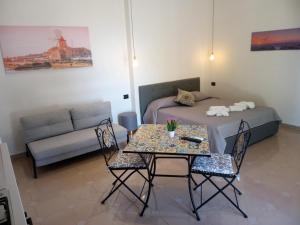 伯吉维奇Isole Dello Stagnone Apartaments的客厅配有床和桌椅