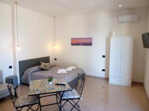 伯吉维奇Isole Dello Stagnone Apartaments的一间卧室配有一张床和一张桌子及椅子