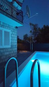ZmijavciHoliday home Goranka的夜晚的游泳池,灯光蓝色