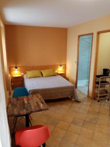 瑟贝里La villa Rosace的卧室配有一张床和一张桌子及椅子