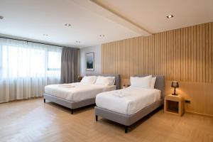 Ban Yangโรงแรมอินฟินิทเกษตร的酒店客房,配有两张床和椅子