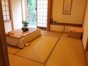 筑波春日ハウス KasugaHouse的客厅配有桌子和窗户