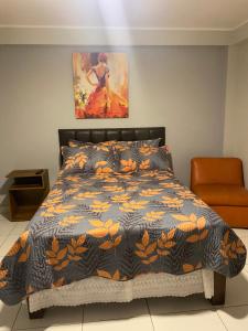 瓦拉尔Los Naturales的一间卧室配有一张带黑色和橙色棉被的床