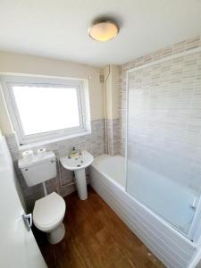 雷利Rayleigh Town Centre 3 Bedroom Apartment的浴室配有卫生间、浴缸和水槽。