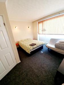 雷利Rayleigh Town Centre 3 Bedroom Apartment的一间卧室设有两张床,其中设有窗户。