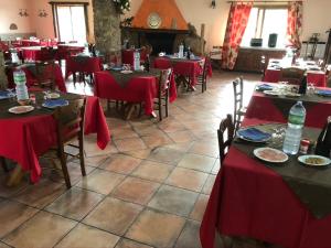 阿尔布斯Agriturismo Rocce Bianche - Bungalows的餐厅设有红色的桌椅和壁炉