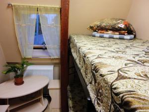 科斯特罗马小旅舍的一间卧室配有一张床、一张桌子和一个窗户。