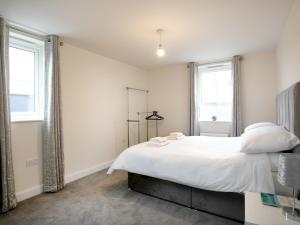 诺丁汉Pass the Keys Stunning 2 bed Apartment with free onsite parking的卧室配有白色的床和2扇窗户。