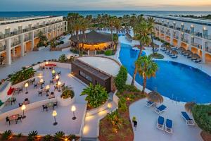 雷塔马尔Hotel Cabogata Jardín的享有带游泳池和棕榈树的度假村的顶部景致