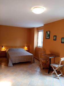 瑟贝里La villa Rosace的卧室配有一张床和一张桌子及椅子