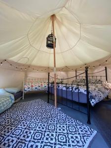 利明顿Secret Garden Glamping的一间帐篷内带两张床的卧室