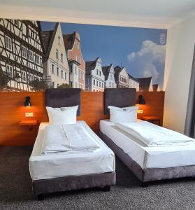 金茨堡宫兹伯格欧陆酒​​店的一张壁画房间内的两张床