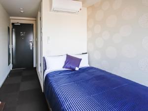 京都HOTEL LiVEMAX Kyoto Nijojo-kita的一间卧室配有一张带蓝色棉被的床