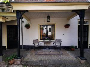 阿尔克马尔Unique Courtyard House with Sauna in Alkmaar city center的门廊配有两把椅子和一张桌子,位于房子前面