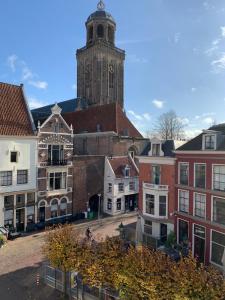 迪温特Hostel Deventer, Short Stay Deventer, hartje stad, aan de IJssel,的一座以钟楼为背景的城市