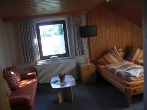 拜尔里舍艾森施泰恩维森诺旅馆的一间卧室配有一张床、一张桌子和一个窗户。