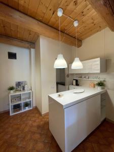 法布里亚诺Il Borghetto Medievale suite的厨房配有白色的柜台和两个吊灯